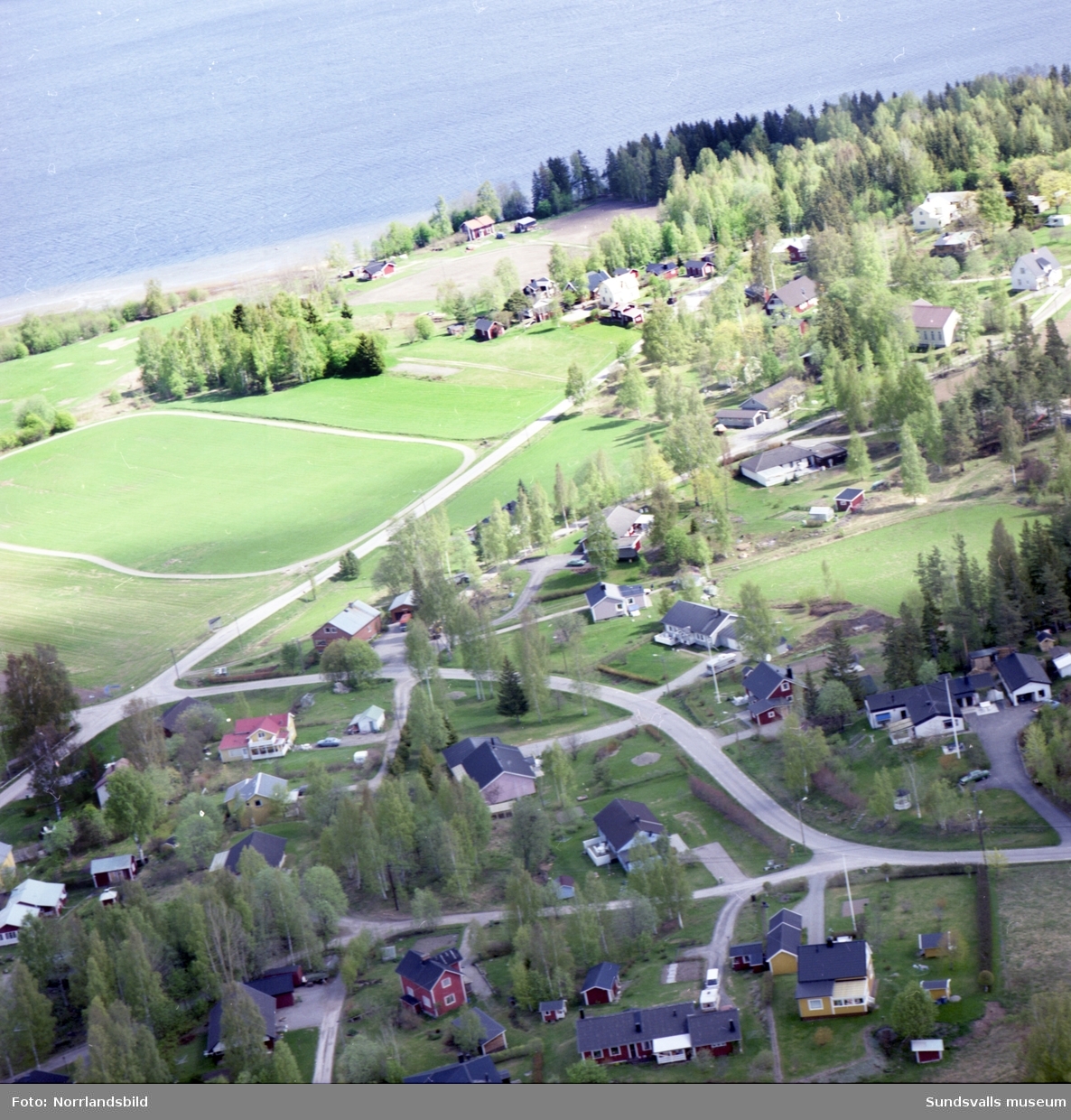Flygfoton över Eriksdal på norra Alnö. Villor och ängsmark ned mot